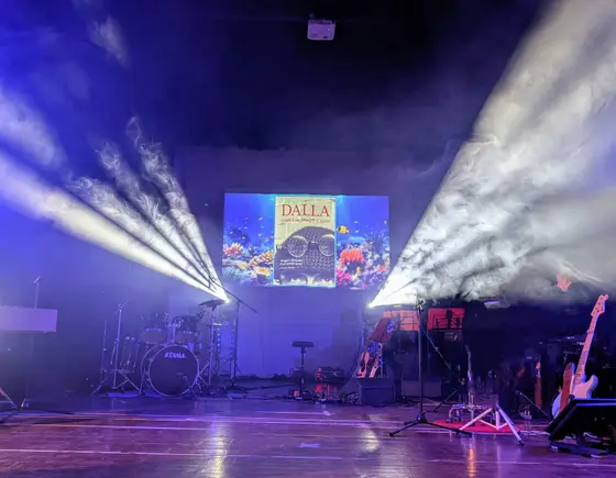Fasci di luce che attraversano la platea del teatro